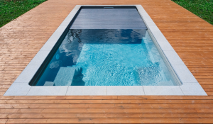 Swimming pool with a secure automatic cover retaining heat and reducing evaporation.