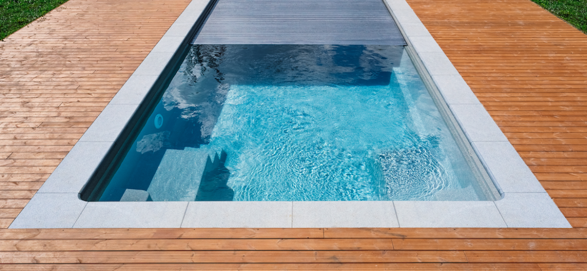 Swimming pool with a secure automatic cover retaining heat and reducing evaporation.