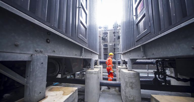 worker inspects industrial equipment in a confined space