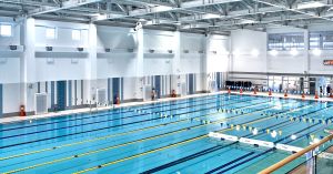 Large indoor Olympic-sized swimming pool for competition with multiple lap lanes and starting blocks